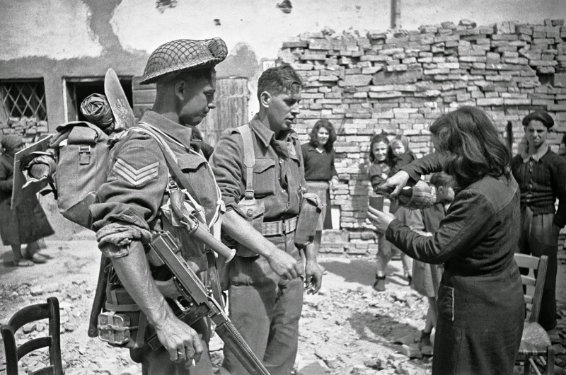 Итальянская женщина угощает вином новозеландских пехотинцев в Барбьяно. Апрель 1945 г.