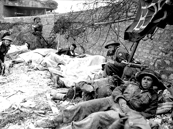Раненые канадские солдаты ожидают эвакуации на пляже Юнона. 6 июня 1944 г.