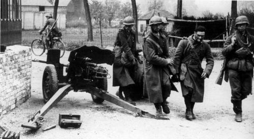 Пленные французские солдаты несут раненого товарища в бельгийский город. 1940 г.