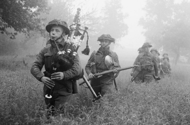 Волынщик 7-го полка горцев Сифорта возглавляет колонну наступающих в районе города Кан. 26 июня 1944 г. 