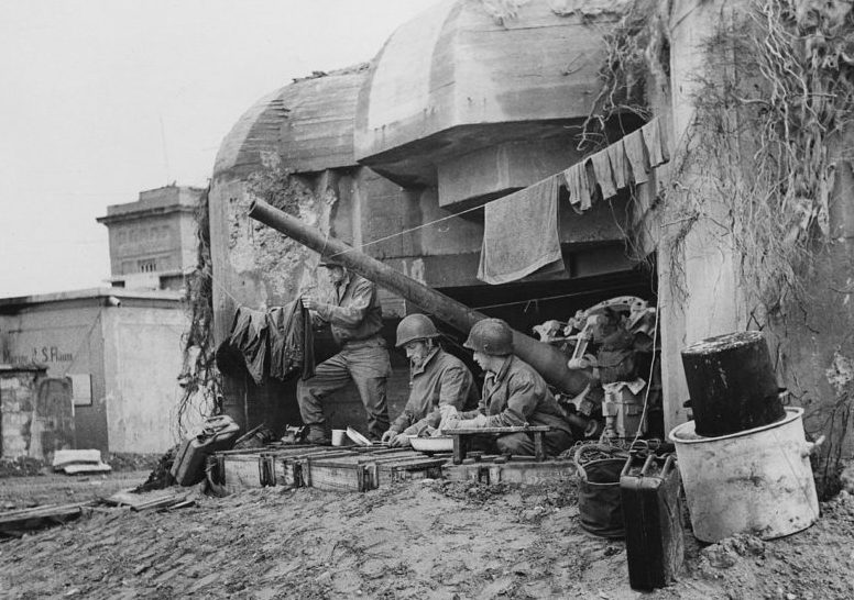 Американские солдаты у захваченного бункера берегового орудия. 10 июля 1944 г.
