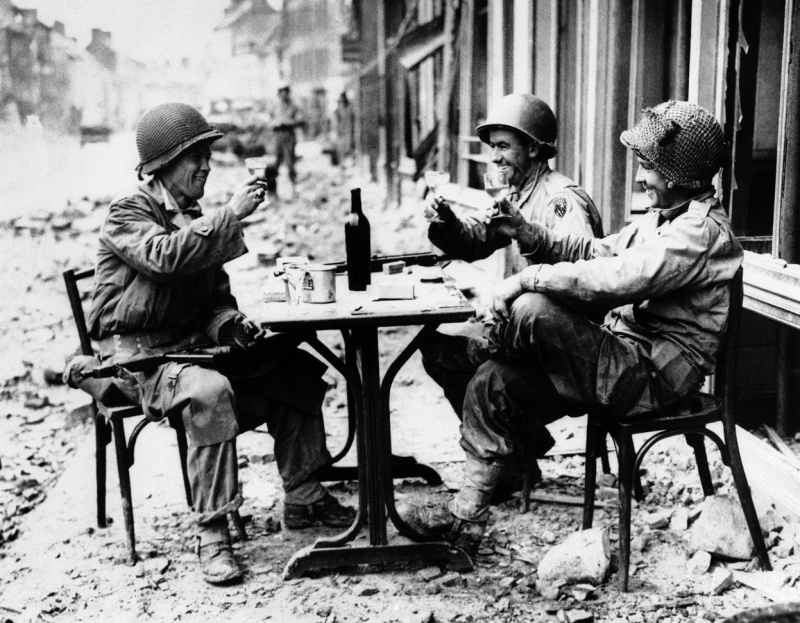 Американские военные изображают уличное кафе на улице городка Ла Э-дю-Пюи. 15 июля 1944 г. 