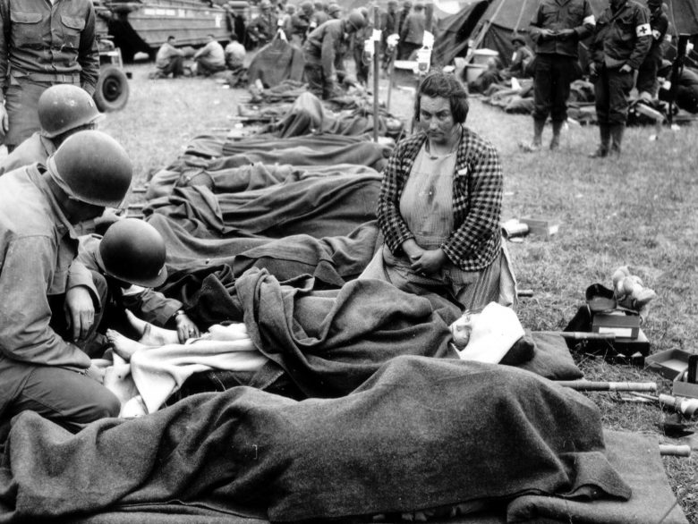 Американский полевой госпиталь. Местная жительница у носилок своего раненого ребенка. 1944 г. 