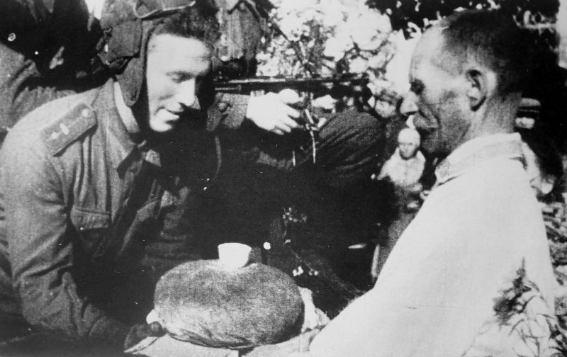 Житель освобожденного Глухова вручает танкисту хлеб с солью. 30 августа 1943 г. 