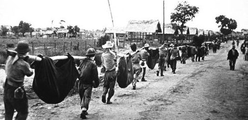 Американские военнопленные на подручных носилках несут своих товарищей во время «Марша смерти» в Батаане. Филиппины, май 1942 г. 