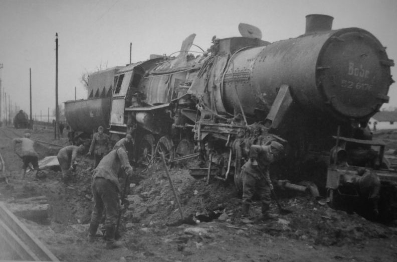 Немецкие солдаты засыпают воронку и ремонтируют полотно у подорванного паровоза. Октябрь 1943 г. 