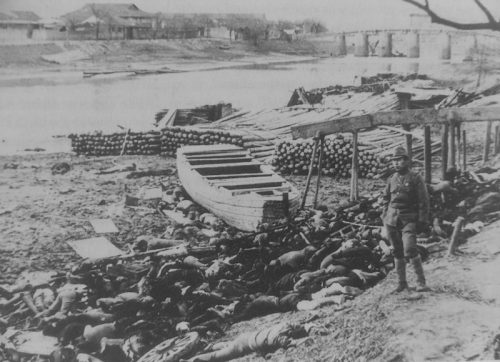 Офицер японской армии стоит возле тел китайцев, убитых японскими военными в Нанкине. Декабрь 1937 г.