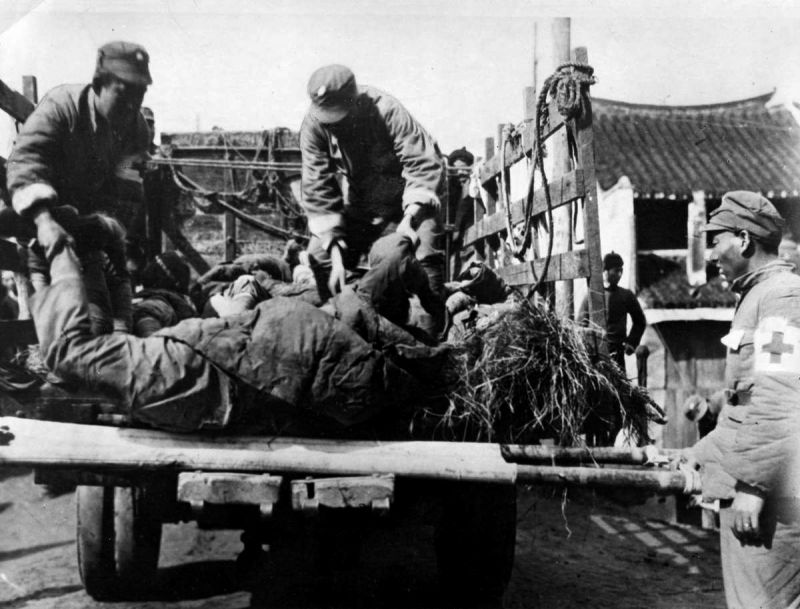 Китайские санитары грузят тела убитых в грузовик на улице Шанхая. Октябрь 1937 г.