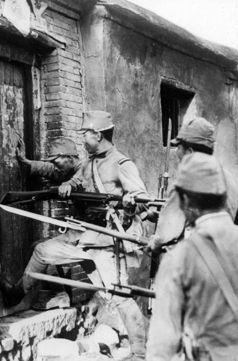 Японские солдаты выламывают дверь дома. 1937 г. 