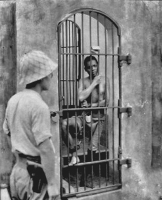 Солдат японской армии, охраняющий пленного филиппинца. Манила, 1942 г.