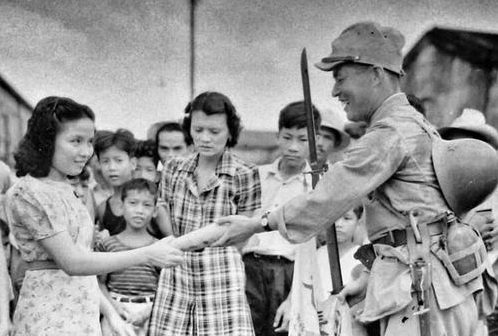 Пропагандистская фотография японского солдата, которого приветствуют филиппинцы. Манила, 1942 г.