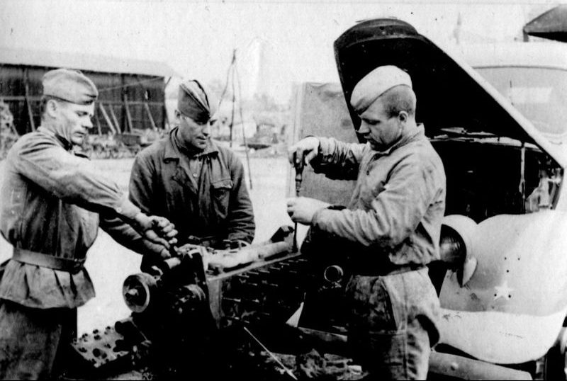 Советские военнослужащие за ремонтом двигателя грузовика. 