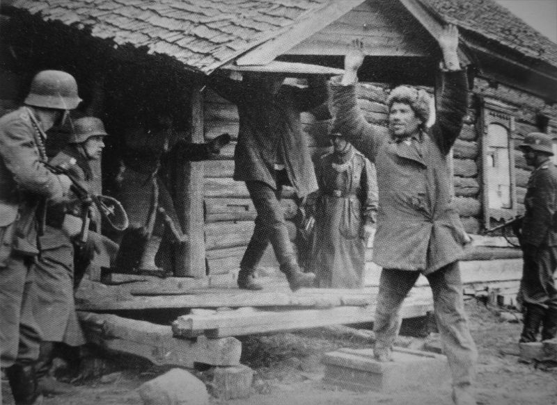 Полевые жандармы выводят из дома схваченных советских партизан. Пропагандистское фото.1941 г.