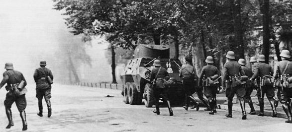 Немецкая штурмовая группа под прикрытием бронеавтомобиля ADGZ идёт на приступ польского главпочтамта в Данциге. 2 сентября 1939 г.
