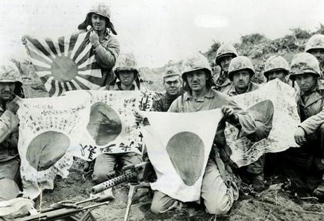 Морские пехотинцы с японскими флагами, захваченными на острове Иводзима. Февраль 1945 г.