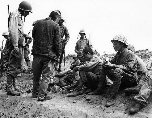 Американские морские пехотинцы кормят японских пленных на Иводзиме. Февраль 1945 г.