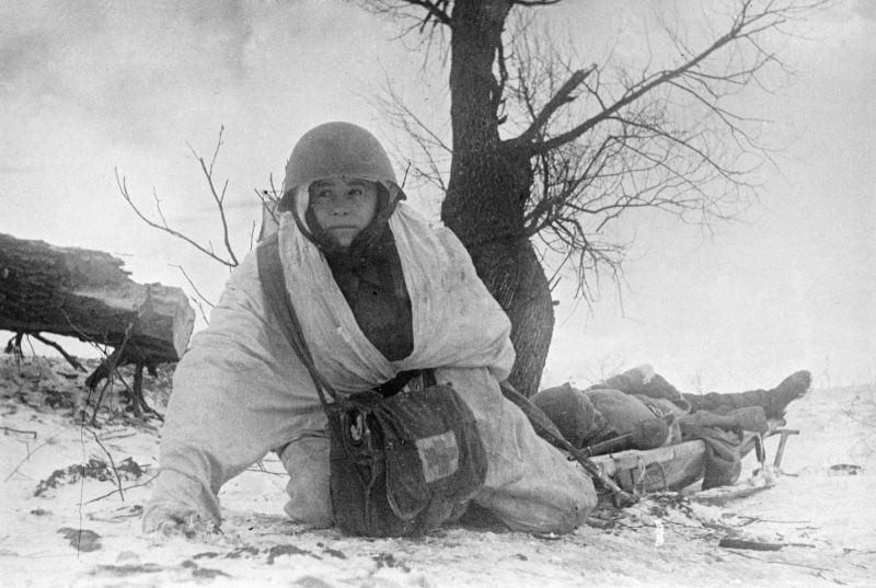 Санинструктор вывозит на санях-носилках красноармейца, раненого на Западном фронте.