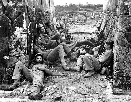 Утомленные боем морские пехотинцы 6-й дивизии отдыхают между боями за город Наха на Окинаве. Апрель 1945 г.