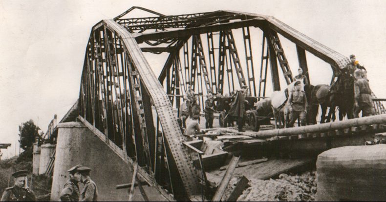 Красноармейцы переправляются по взорванному мосту.
