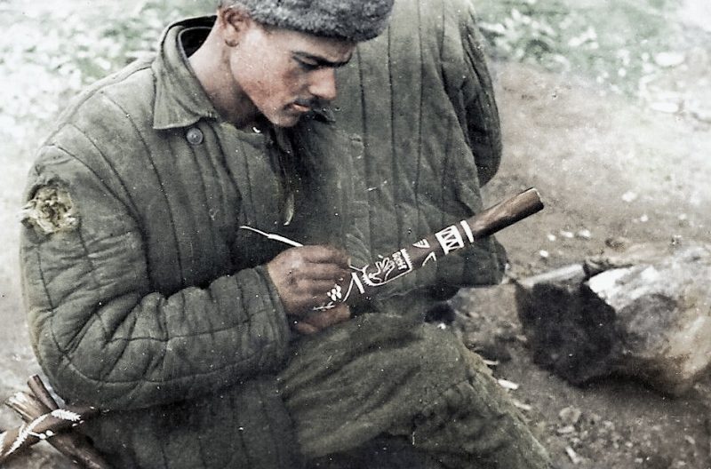 Советский военнопленный в лагере занимается вырезанием памятной трости с изображением эмблемы 122-й пехотной дивизии. Павловск, осень 1941 г.