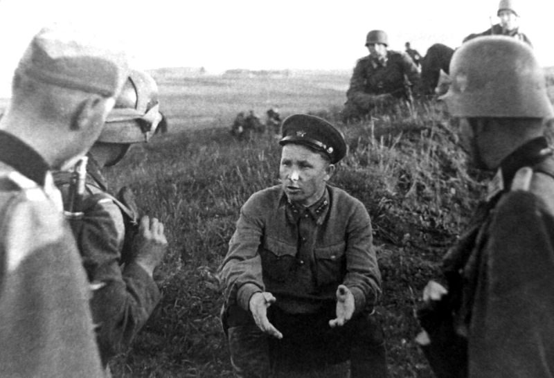 Немецкие офицеры допрашивают советского политрука-пограничника, пленённого ими на литовском берегу озера Выштынец. 22 июня 1941 г.