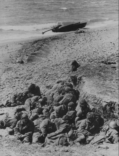 Группа пленных красноармейцев сидит на берегу Керченского пролива. 1942 г.