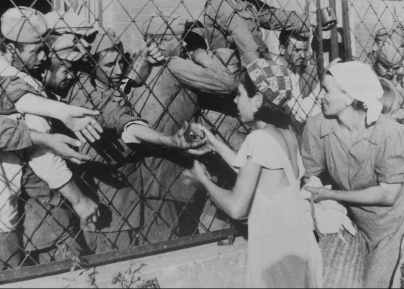 Женщина и девочка передают хлеб советским военнопленным. Украина, лето 1941 г. 
