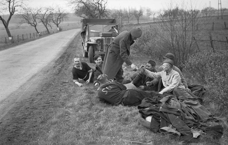 Британский солдат угощает сигаретами освобожденных советских военнопленных на дороге к у Ганновера. 10 апреля 1945 г. 