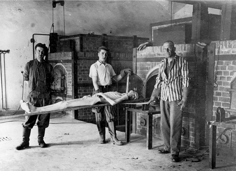 Заключенные демонстрируют процесс уничтожения трупов в крематории концлагеря Дахау.