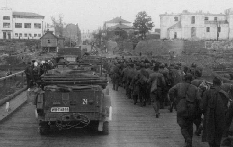 Пленные красноармейцы и немецкие автомобили на мосту через реку Буг в Бресте. 1941 г. 