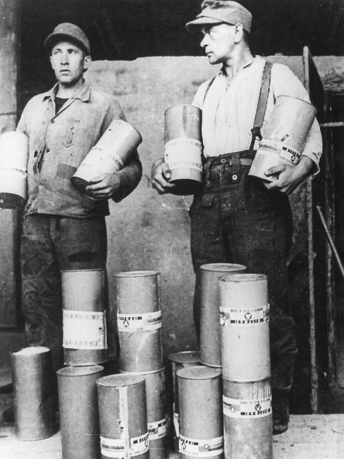 Двое немцев, работавших в газовых камерах с контейнерами отравляющего газа «Циклон-Б» в концлагере Майданек. Июль 1944 г.