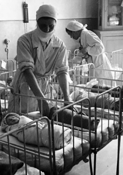 Медсестры укладывают новорожденных в кроватки. Ленинград, 1942 г.