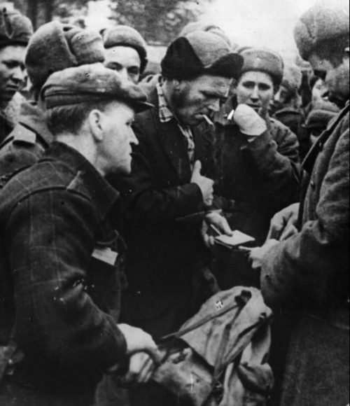Норвежские мирные жители производят обмен вещами с советскими бойцами. 1944 г.