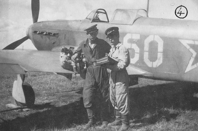 Пилоты истребители лейтенант Георгий Сисин и младший лейтенант Сергей Марийченко у истребителя Як-9. Август 1945 г.