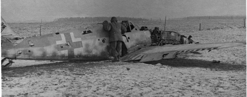 Американский солдат осматривает сбитый в районе Отона немецкий истребитель Мессершмитт Bf.109. Декабрь 1944 г.