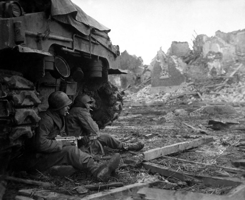 Перекур американских солдат, укрывшихся за танком. Бельгия. Декабрь 1944 г.