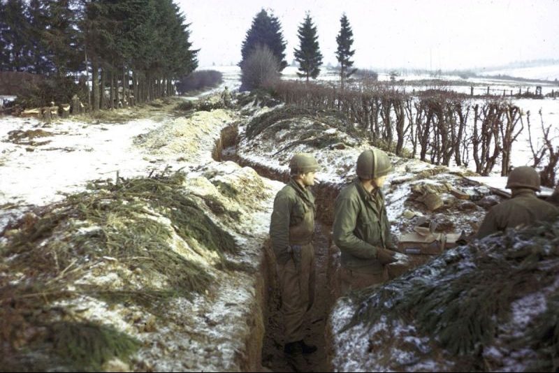 Трое американских солдат в окопе на опушке Арденнского леса. Январь 1945 г.