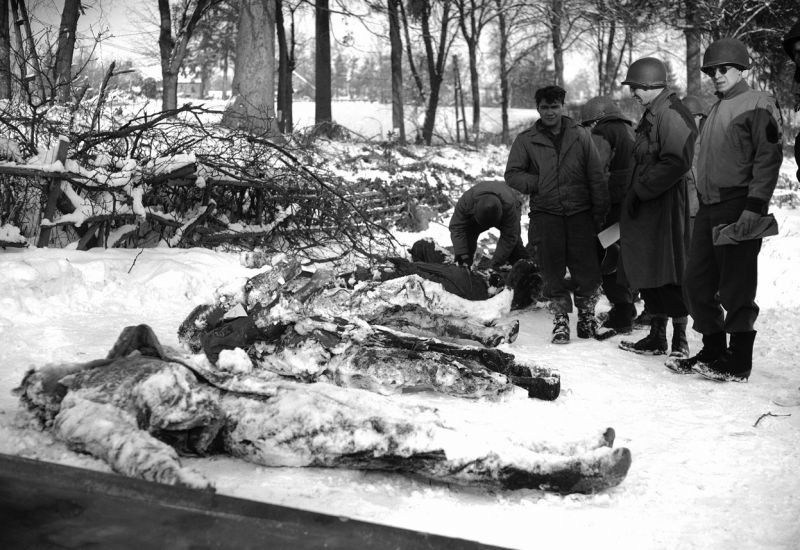 Американские военнослужащие у тел погибших товарищей во время опознания. Январь 1945 г.