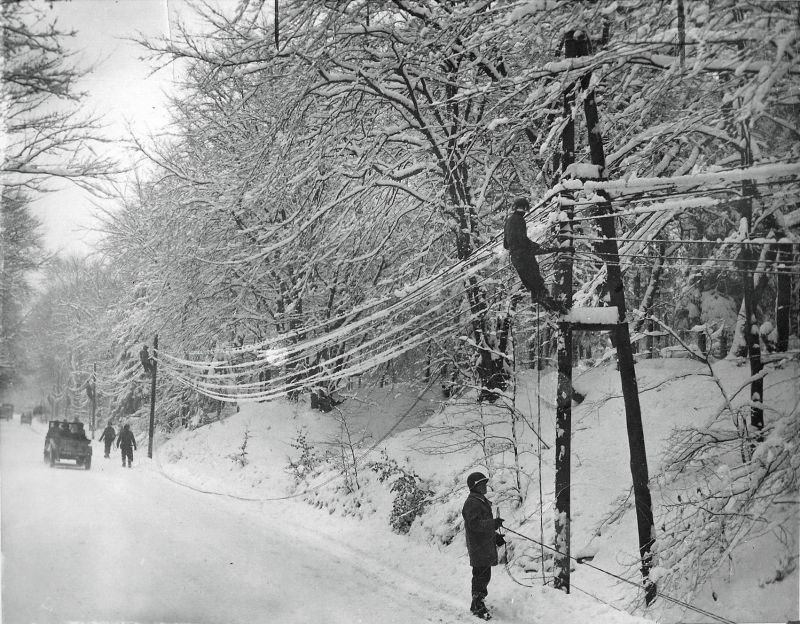 Связисты 1-й армии США прокладывают линию на заснеженной дороге в Бельгии. Январь 1945 г.