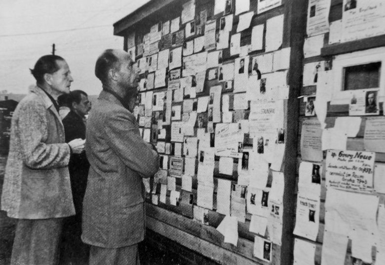 Бывшие военнопленные, вернувшиеся в Германию из СССР, читают объявления о розыске родственников, оказавшихся в плену, в приемном «лагере Фридланд». 1955 г. 