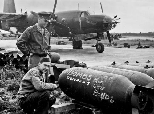 Члены экипажа бомбардировщика B-26 под названием «Ангелы ада» пишут «послание» противнику на корпусе 900-килограммовых бомб Ан-М66. Аэродром в Грейт-Данмоу, Великобритания. Август 1944 г.