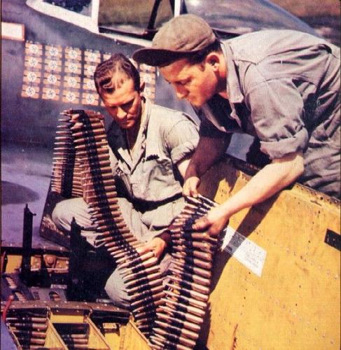 Оружейники загружают пулеметную ленту для крыльевых пулеметов истребителя P-51B «Мустанг». Сентябрь 1944 г. 