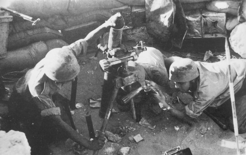 Немецкие парашютисты ведут огонь из 81-мм миномета во время боев в Тунисе. 1943 г. 