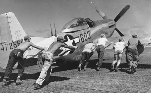 Наземный персонал толкает P-51 Mustang на аэродроме Иводзимы. Июль 1945 г. 