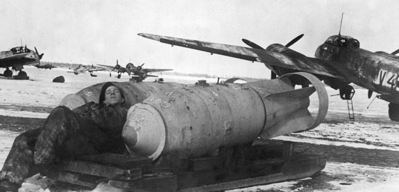 Авиатехник дремлет на 1000-кг бомбах SC 1000 на аэродроме в Пскове. Апрель 1942 г. 