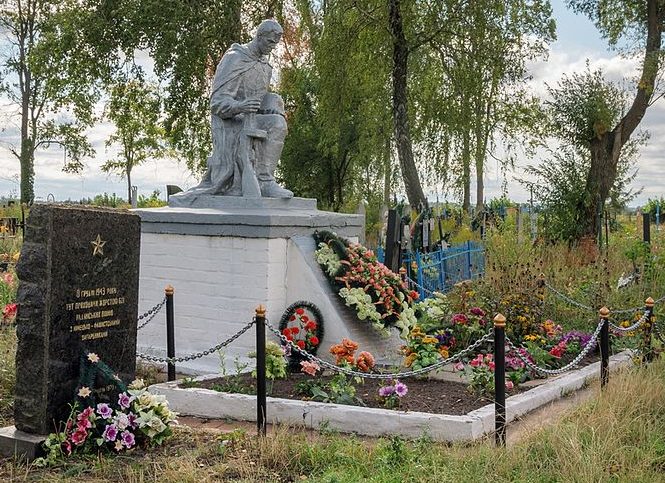 с. Дворец Житомирского р-на. Памятник, установленный на братской могиле, в которой похоронено 33 советских воинов и памятный знак на месте боев. 