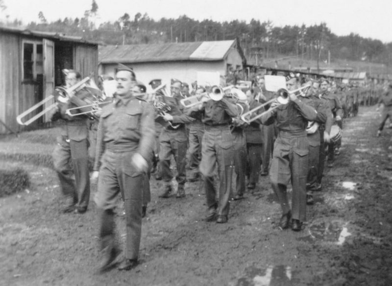 Парад пленных союзников (австралийцы, британцы и новозеландцы) с оркестром вокруг бараков в Шталаге XVIIIA. 