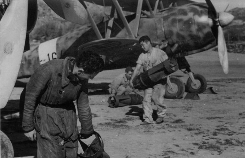 Техники подвешивают авиабомбы под крылья истребителей-бомбардировщиков Fiat CR.42 «Falco» на Средиземноморье. Май 1942 г. 