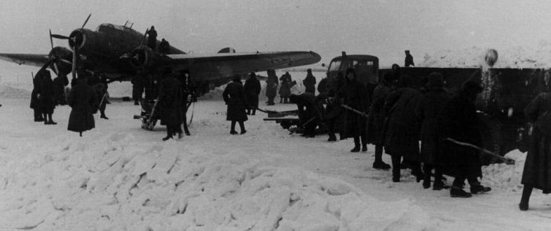 Советские военнопленные и мирные жители на работах по уборке снега на аэродроме. Зима 1942 г. 
