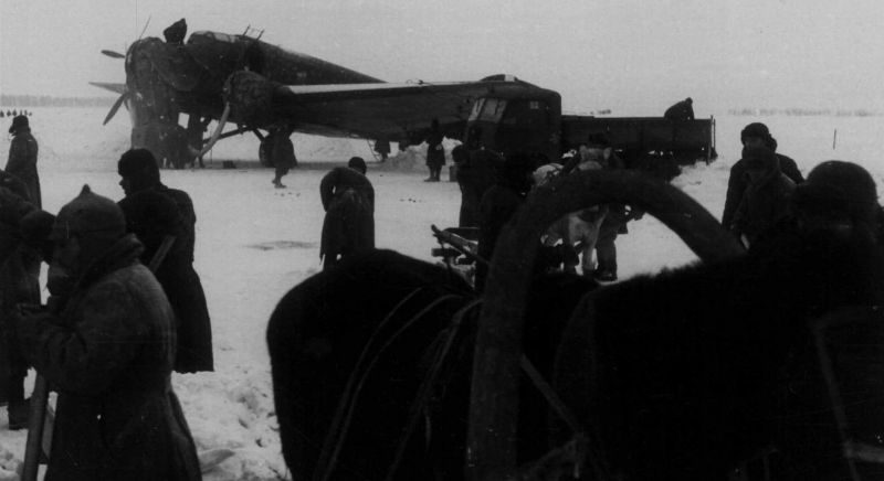 Советские военнопленные и мирные жители на работах по уборке снега на аэродроме. Зима 1942 г. 